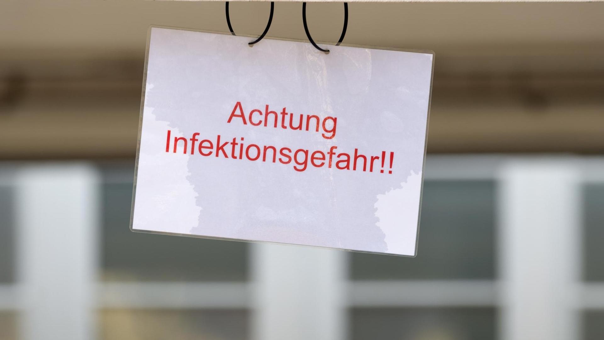Ein Schild mit der Aufschrift "Achtung Infektionsgefahr" ist an einem Zelt zur Untersuchung von Corona-Verdachtsfällen an der Einfahrt zum Johanniter-Krankenhaus in Treuenbrietzen in Brandenburg angebracht, aufgenommen am 15. März 2020.