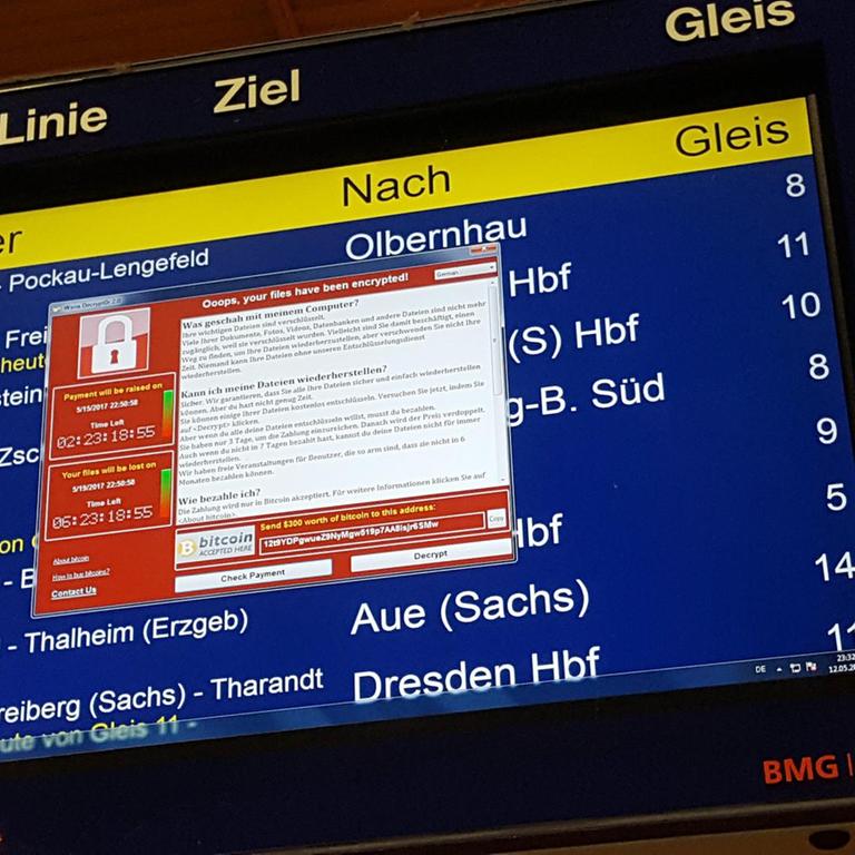 Die Anzeigetafel zeigt Zugabfahrten an, davor erscheint in rot der Text der Erpresser. 