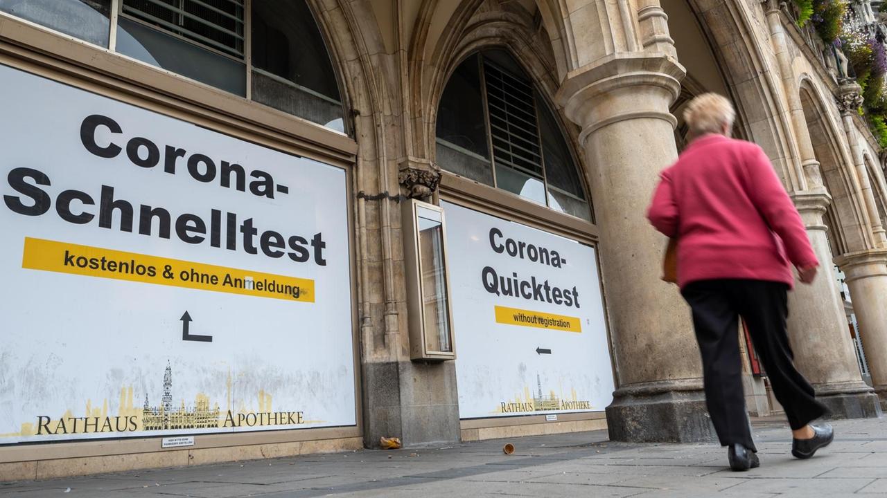 Eine Frau geht in der Innenstadt an einem Testzentrum vorbei, das gratis Corona-Schnelltest auch ohne Anmeldung anbietet.