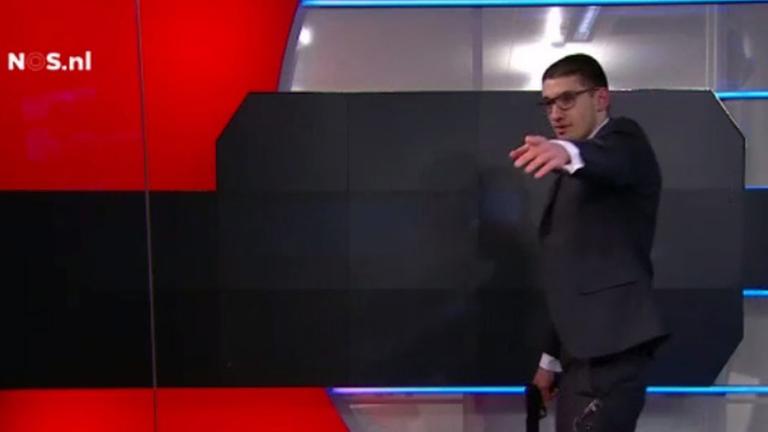 Ausschnitt aus Fernsehaufnahmen, die einen Mann mit einer Pistole in der Hand in einem TV-Studio zeigen.