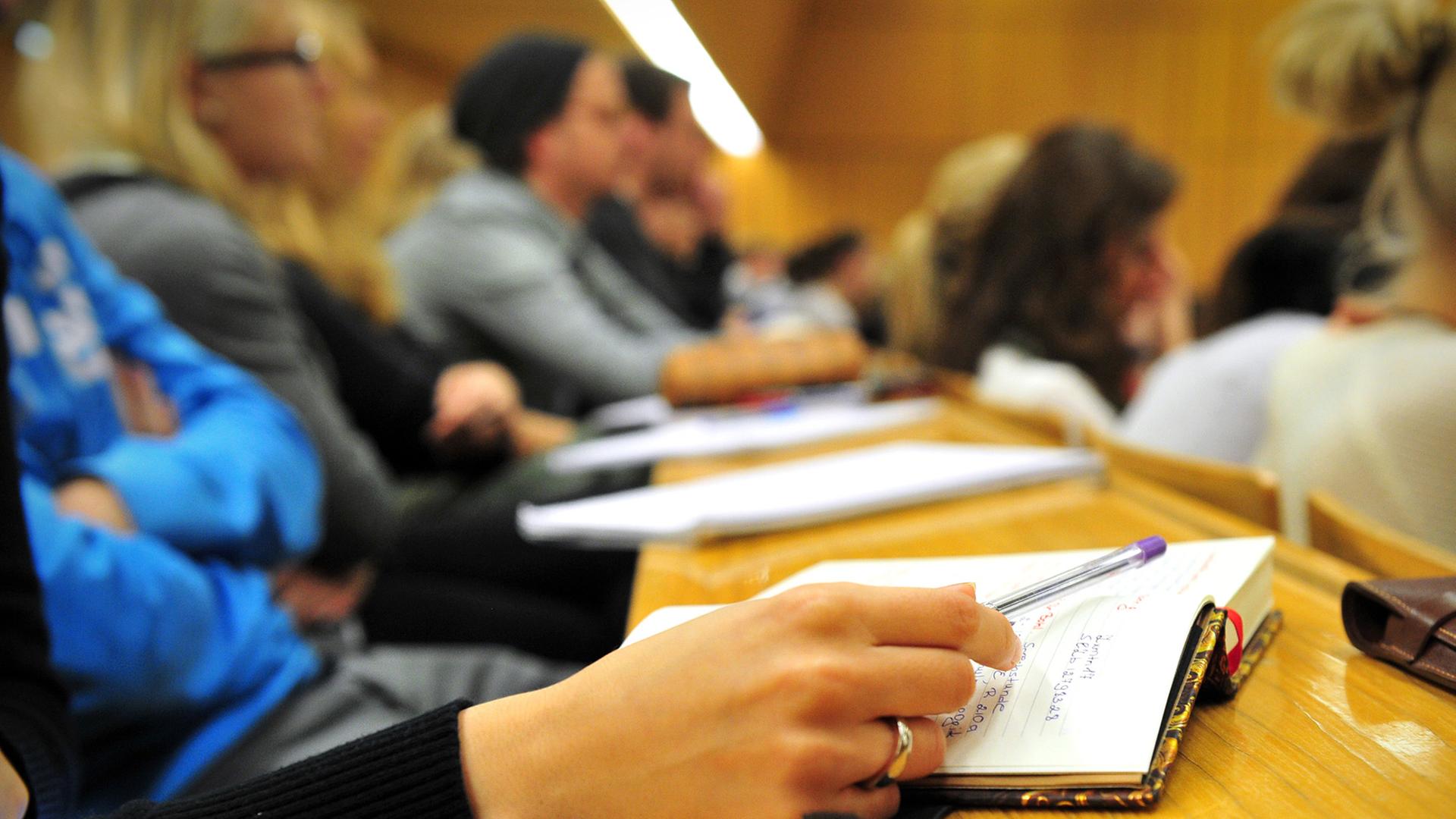 Eine Studentin der Schulpädagogik schreibt am 17.10.2012 während einer Vorlesung in einem vollen Hörsaal in der Universität in Tübingen (Baden-Württemberg) mit.