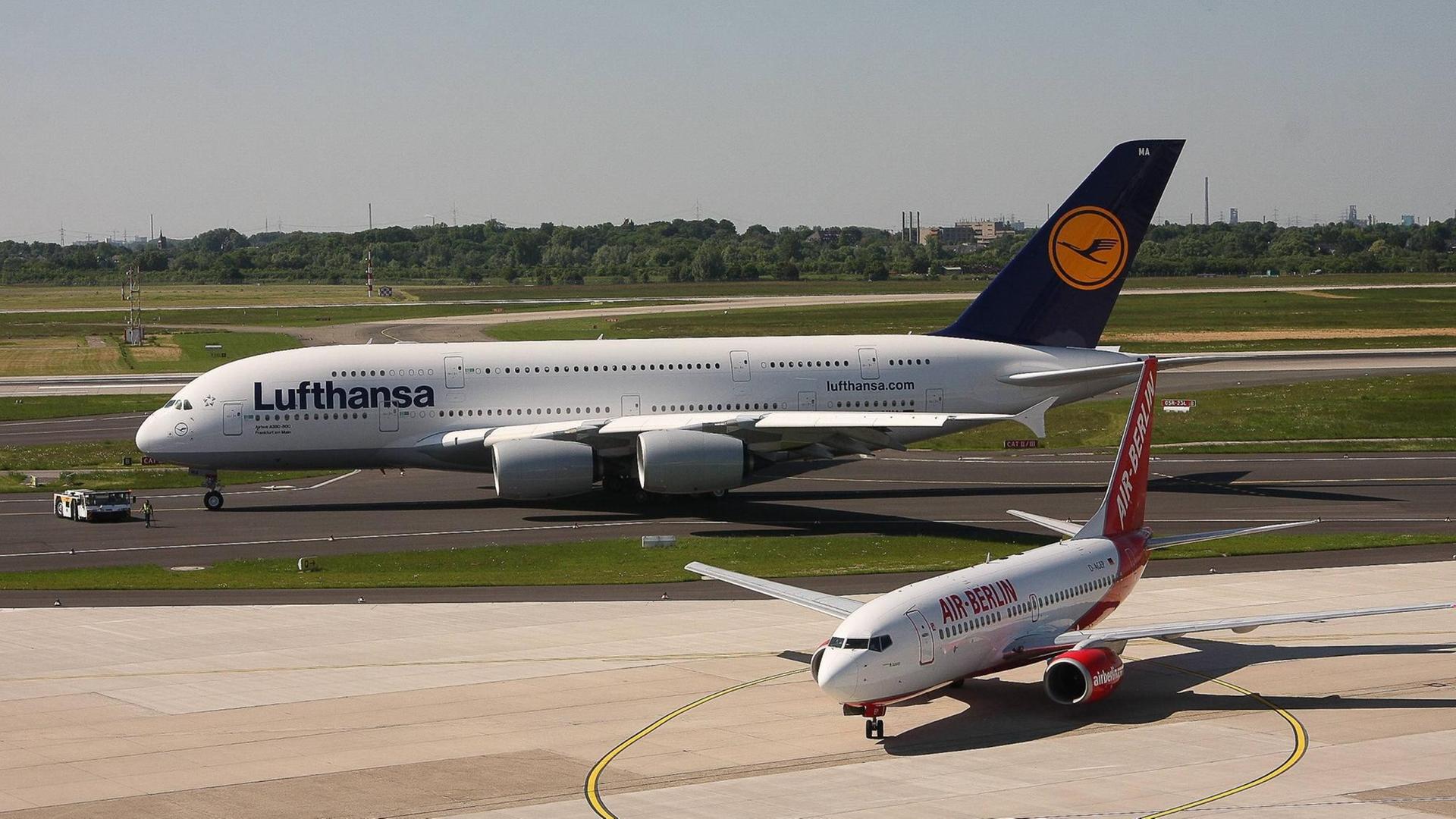 Ein Airbus A380-841 der Lufthansa neben einer Boeing 737-75B von Air Berlin auf dem Düsseldorfer Flughafen.