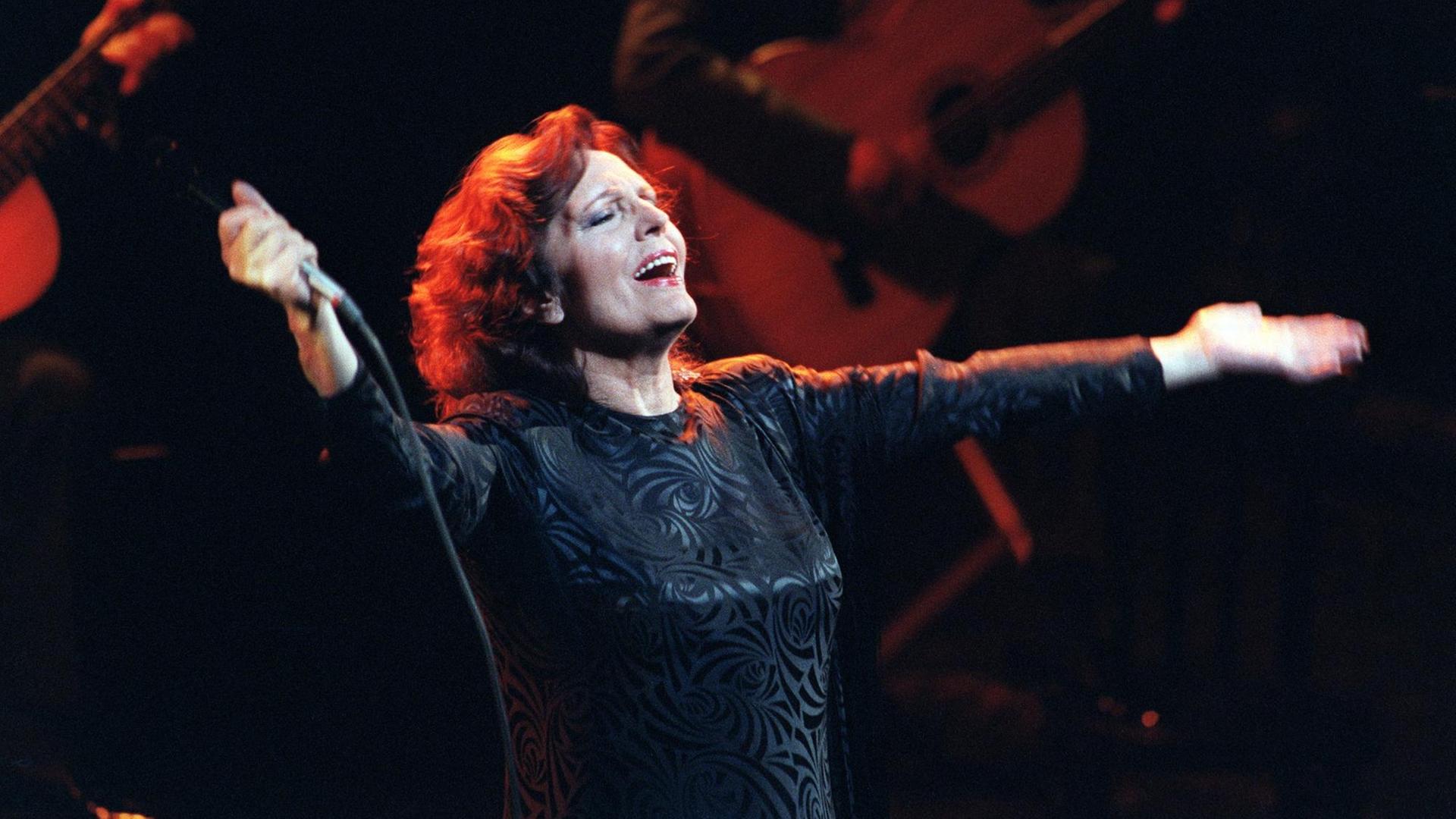 Portuguese singer Amalia Rodrigues performs on the Olympia concert hall stage, on April 21, 1987 in Paris. Rodrigues' speciality was fado, traditional Portuguese singing that emphasizes the themes of nostalgia sadness, love and death. Amalia Rodrigues died 06 October 1999 in Lisbon at the age of 79. (Photo by JACQUES DEMARTHON / AFP)