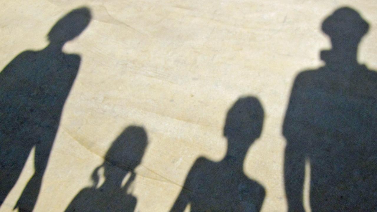 Der Schatten einer Familie, die sich an der Hand hält
