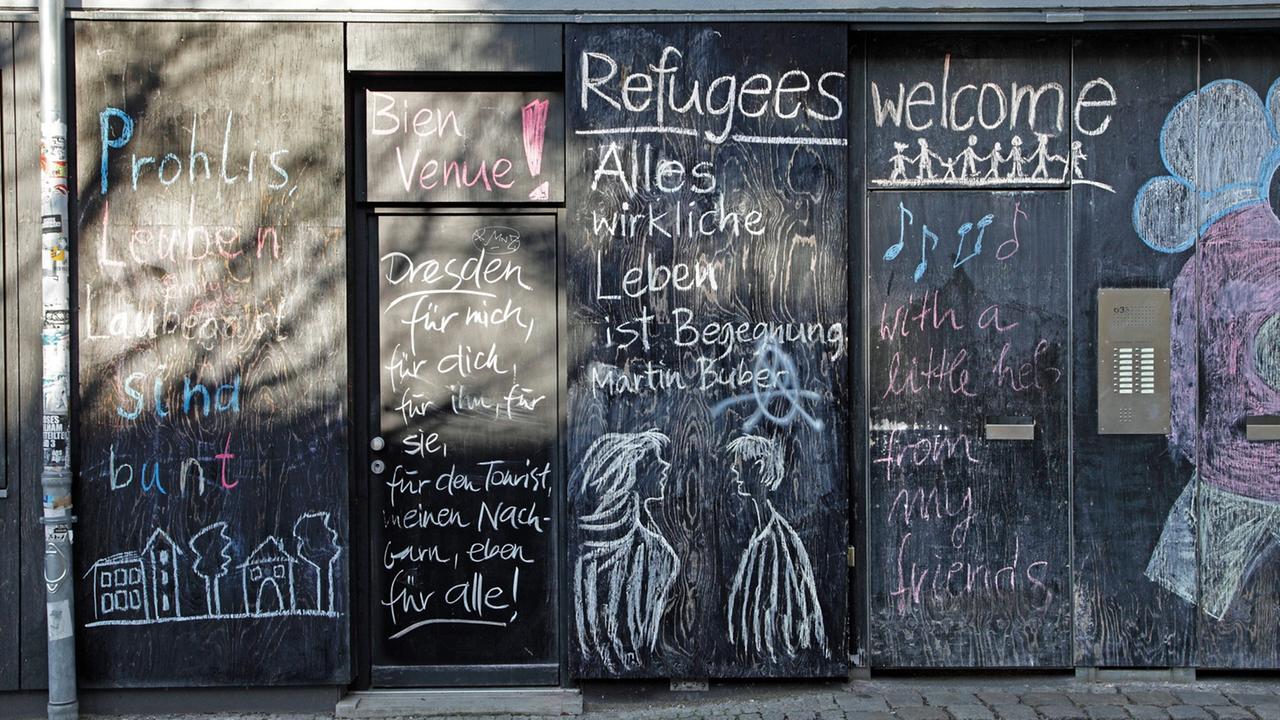 "Refugees welcome" steht in der Dresdener Neustadt auf einer bunt bemalten Hauswand.