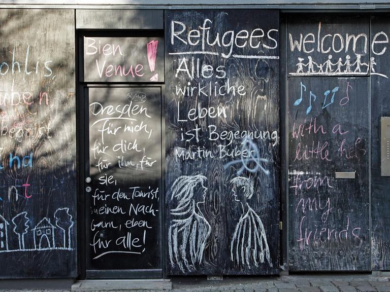 "Refugees welcome" steht in der Dresdener Neustadt auf einer bunt bemalten Hauswand.