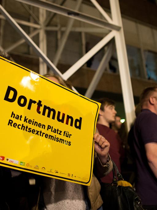 Ein Mann und eine Frau zeigen am 25.05.2014 vor dem Rathaus in Dortmund (Nordrhein-Westfalen) ein Schild mit der Aufschrift "Dortmund hat keinen Platz für Rechtsextremismus". Eine Gruppe von Männern aus dem rechten Umfeld hatten versucht, das Rathaus am Wahlabend zu stürmen, wurde daran aber von Bürgern gehindert.