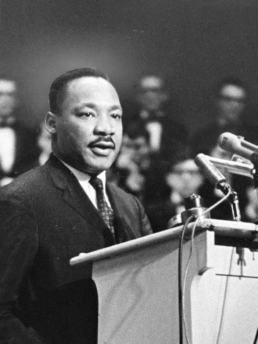 Martin Luther King steht an einem Rednerpult.