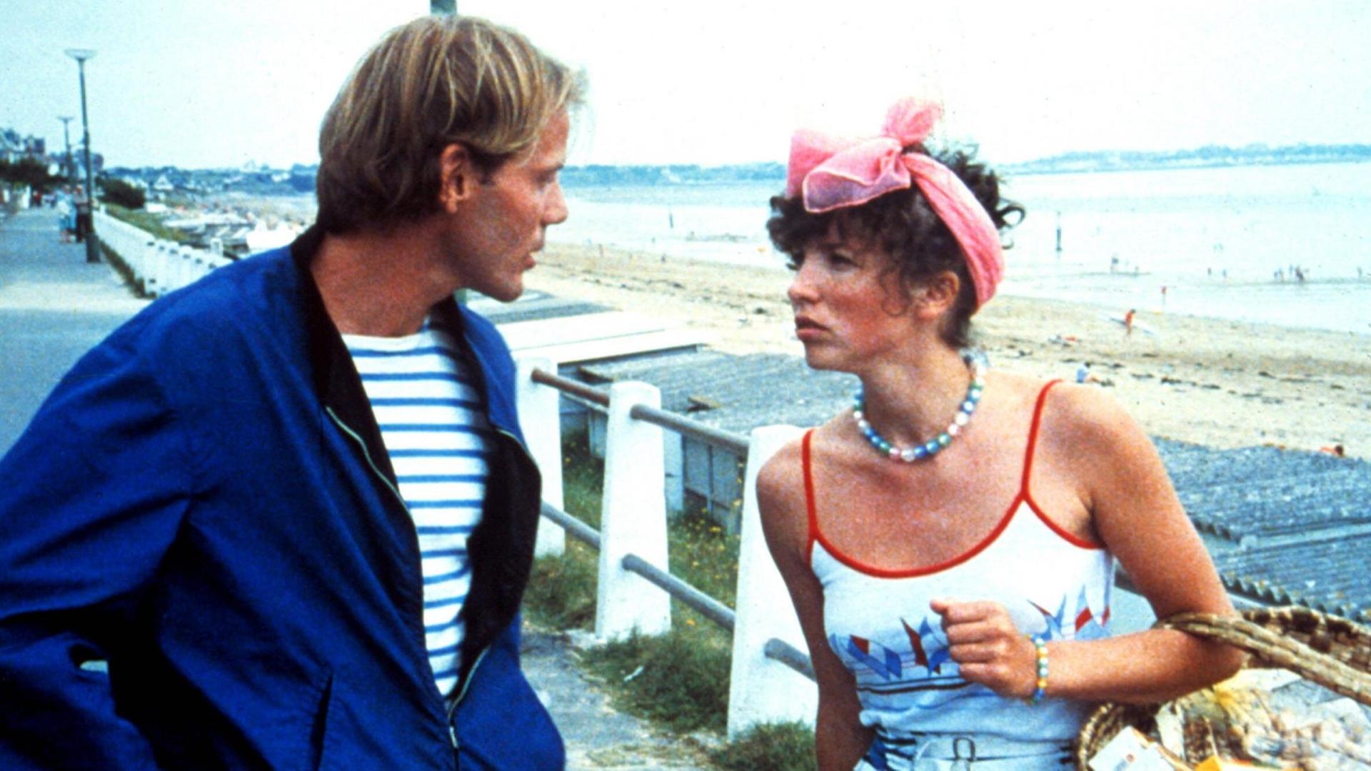 Ein Mann und eine Frau unterhalten sich auf einer Strandpromenade