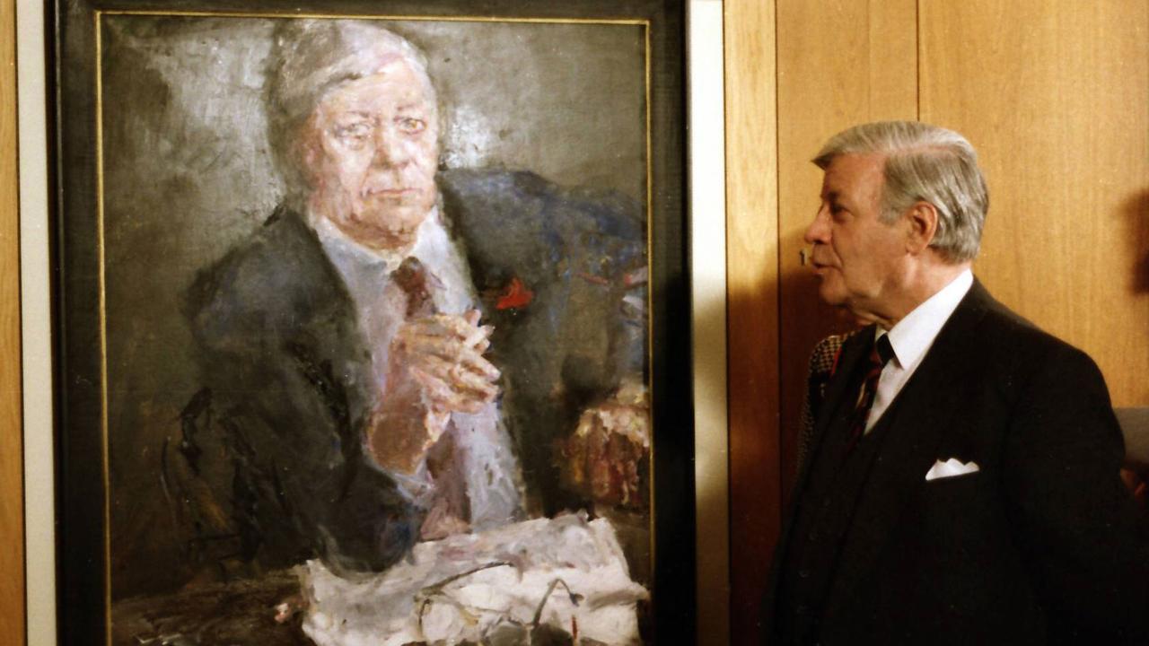 Der frühere Bundeskanzler Helmut Schmidt steht rechts neben seinem Porträt, das der DDR-Maler Bernhard Heisig gemalt hat. Das Ölbild zeigt Schmidt an einem Tisch sitzend mit Zigarette in der Hand.