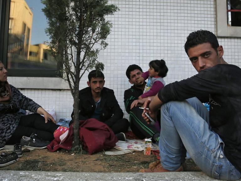 Flüchtlinge warten an einer Bushaltestelle in Istanbul.