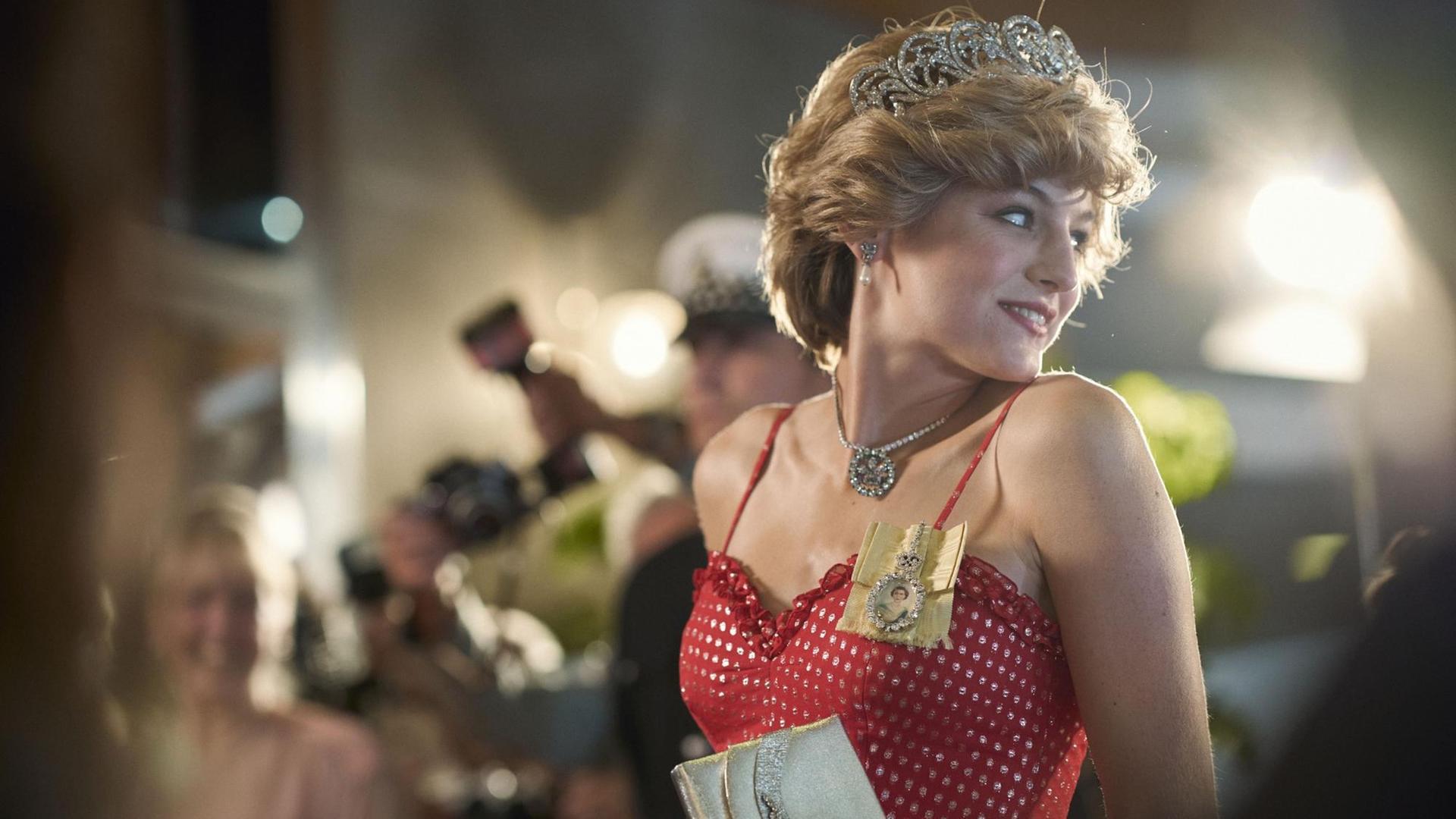 Szene aus "The Crown" Staffel 4, Diana Princess of Wales gespielt von Emma Corrin im Blitzlichtgewitter.