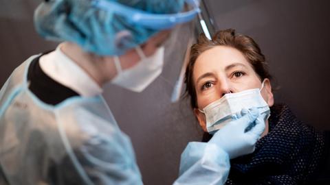 Eine Frau lässt sich in einem Corona-Schnelltest-Zentrum mit einem Nasenabstrich auf das Coronavirus testen.