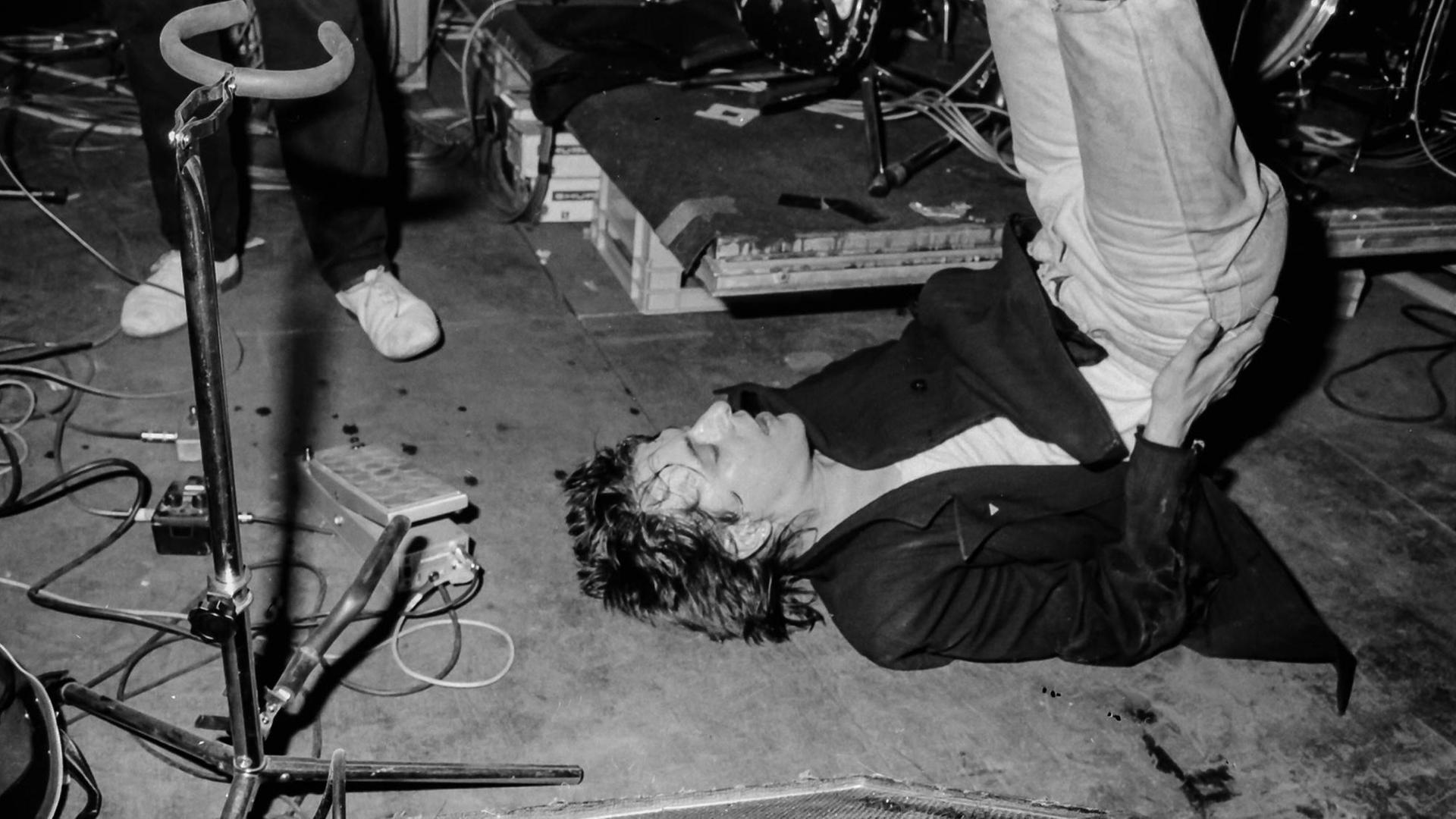 Rio Reiser liegt bei einem Konzert seiner Band Ton Steine Scherben in der UFA Fabrik 1984 auf dem Rücken.