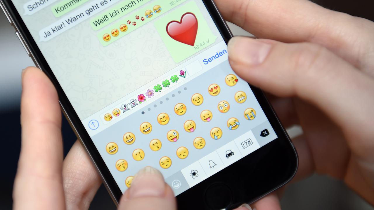 Auf dem Display eines iphone 6 ist am 20.03.2015 ein Chatverlauf der App "WhatsApp" mit Emoticons zu sehen.