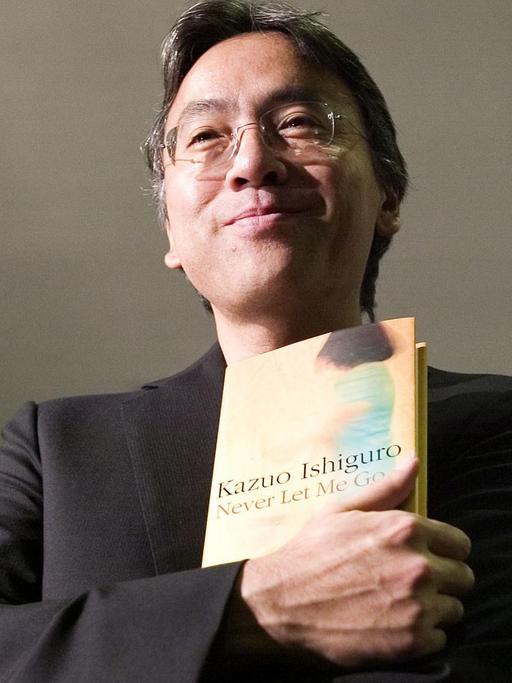 Der britisch-japanische Schriftsteller Kazuo Ishiguro hält eines seiner Bücher in der Hand.