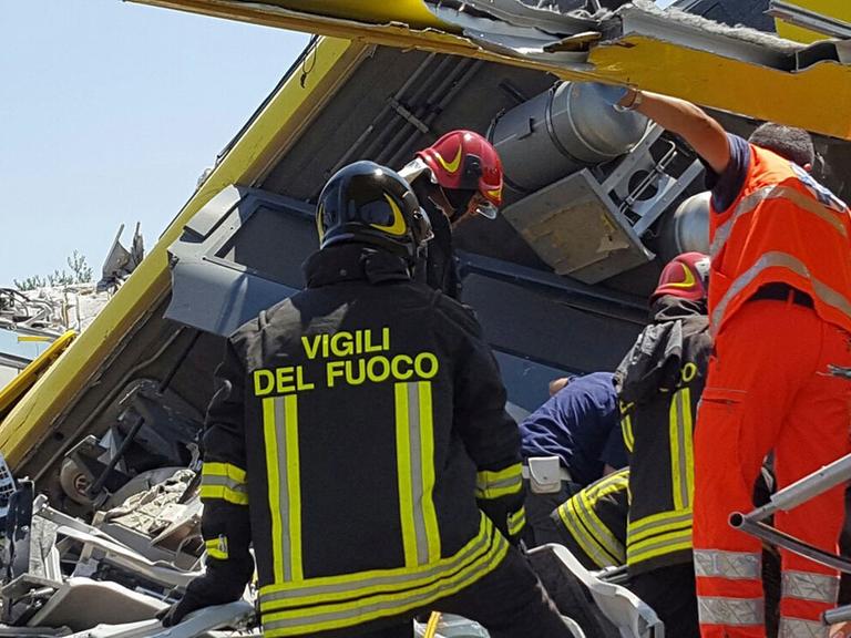 Italienische Rettungskräfte inspizieren das Wrack der beiden verunglückten Pendlerzüge.