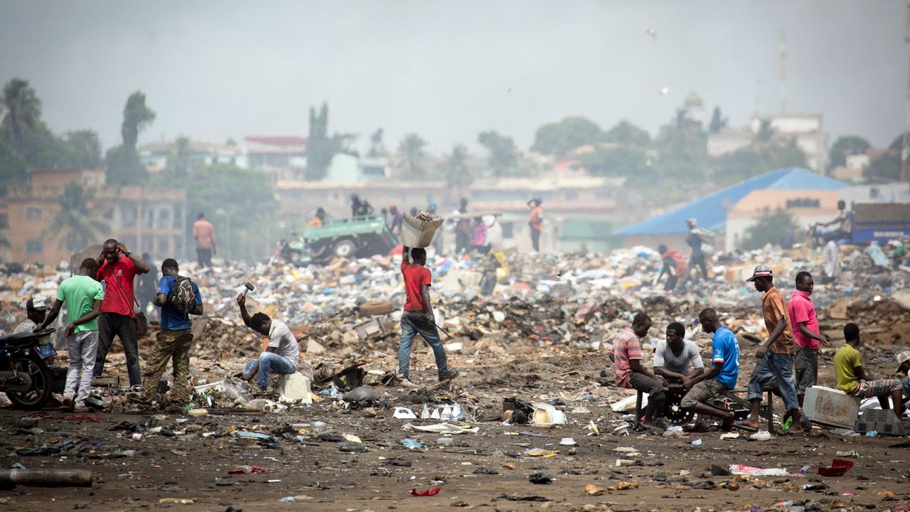 Männer arbeiten am Stadtrand von Accra auf einer Müllhalde aus Elektroschrott. 