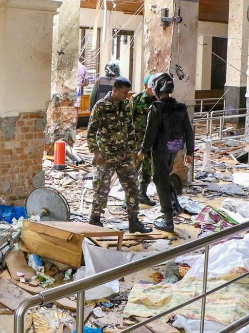 Die St. Antonius Kirche in Colombo ist nach einer Explosion verwüstet, Sicherheitskräfte gehen durch Trümmer