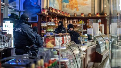 Polizisten stehen bei einer Razzia gegen die Mafia in einem Eiscafé in der Duisburger Innenstadt.