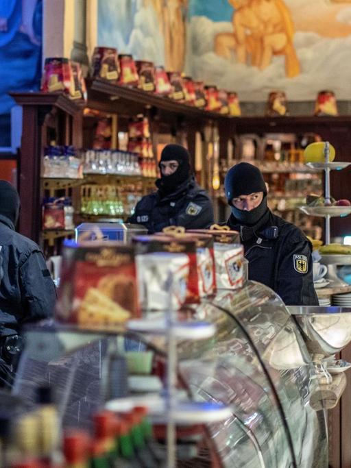 Polizisten stehen bei einer Razzia gegen die Mafia in einem Eiscafé in der Duisburger Innenstadt.