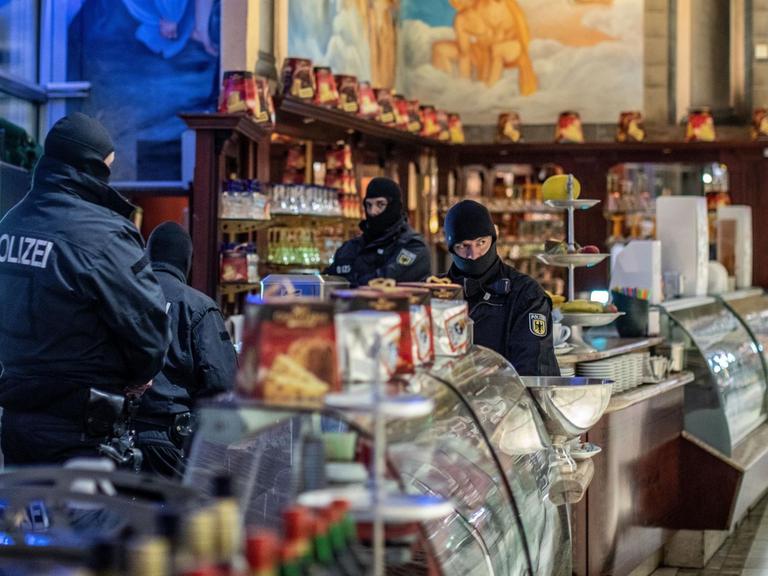 Polizisten stehen bei einer Razzia gegen die Mafia in einem Eiscafé in der Duisburger Innenstadt.