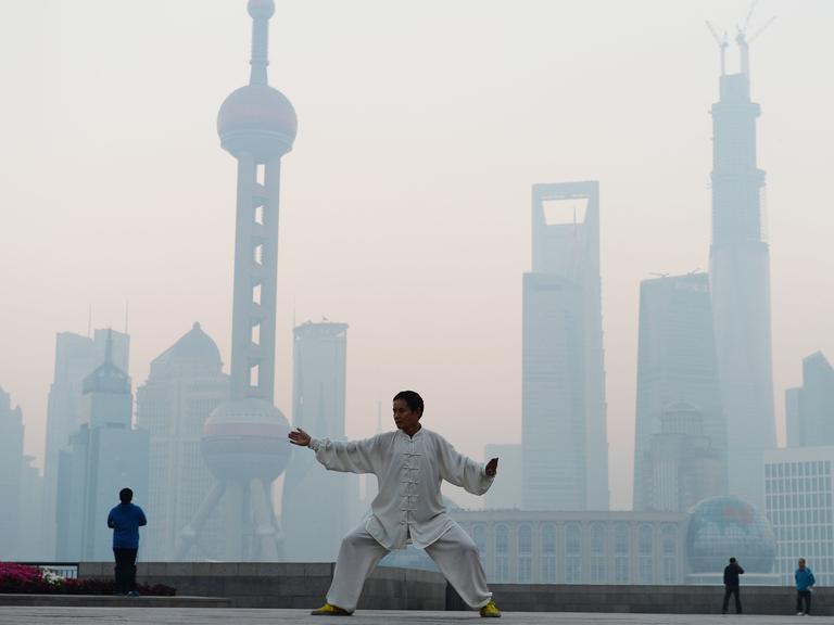 Ein Chinese übt Tai Chi in Shanghai, wo Smog herrscht