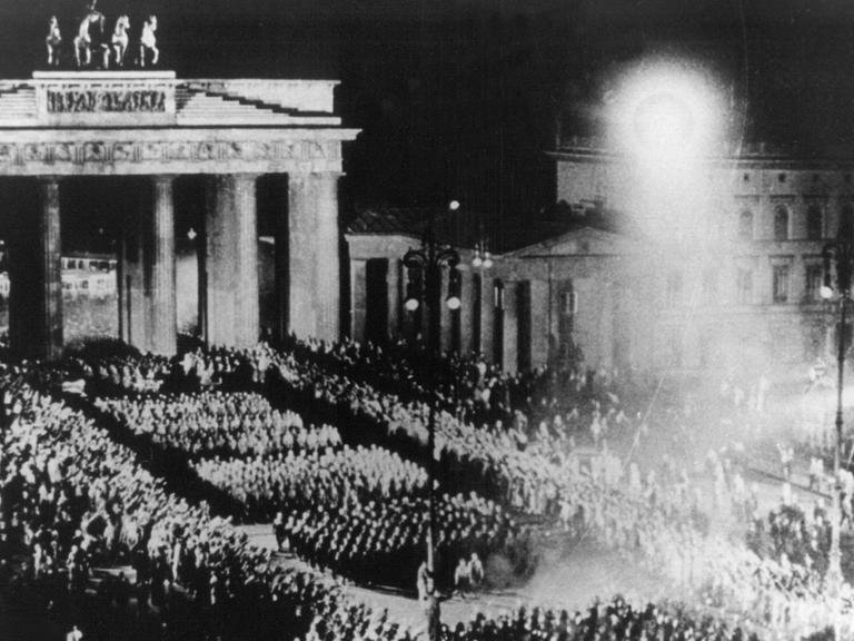Für einen NS-Film nachgestellte Szene des Fackelzugs der SA durch das Brandenburger Tor, mit dem die Nationalsozialisten am 30.01.1933 die Machtübernahme feierten (Archivbild vom Sommer 1933).
