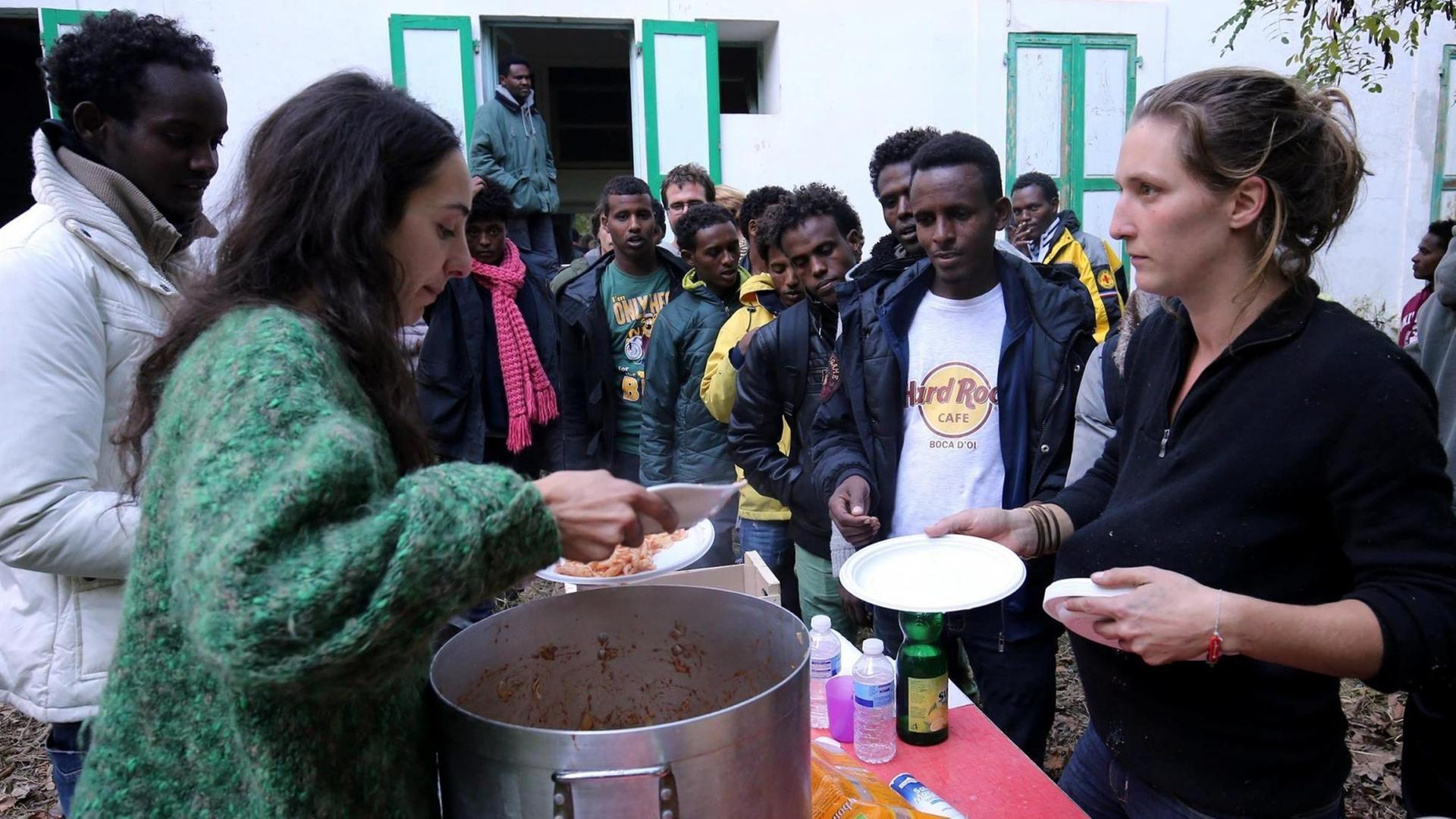 Freiwillige verteilen Essen an Flüchtlinge in einem provisorischen Camp in Saint-Dalmas-de-Tende im äußersten Südosten Frankreichs an der Grenze zu Italien.