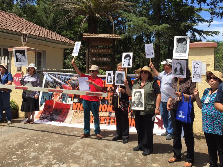 Demonstration von Angehörigen von Opfern der chilenischen Militärdiktatur vor dem verschlossenen Eingang zur Villa Baviera