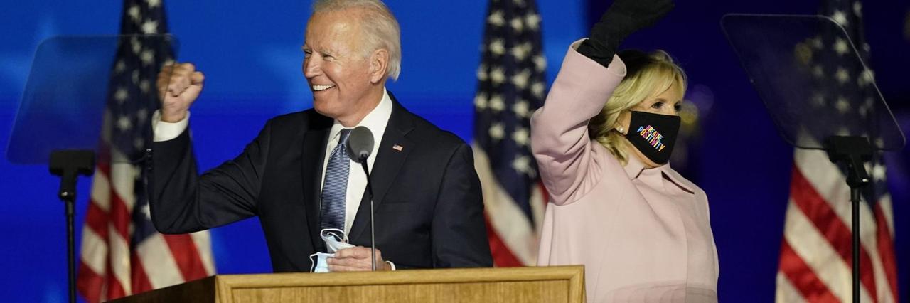 Der demokratische Präsidentschaftskandidat Joe Biden steht mit seiner Frau Jill auf einer Bühne und winkt seinen Anhängern zu.