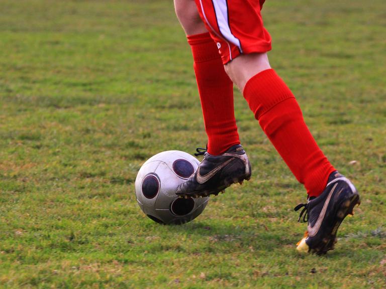 Ein junger Mensch spielt Fußball.