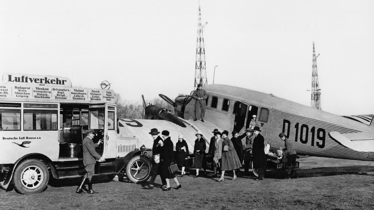 Passagiere steigen aus einem Flugzeug um in einen direkt daneben parkenden Bus.