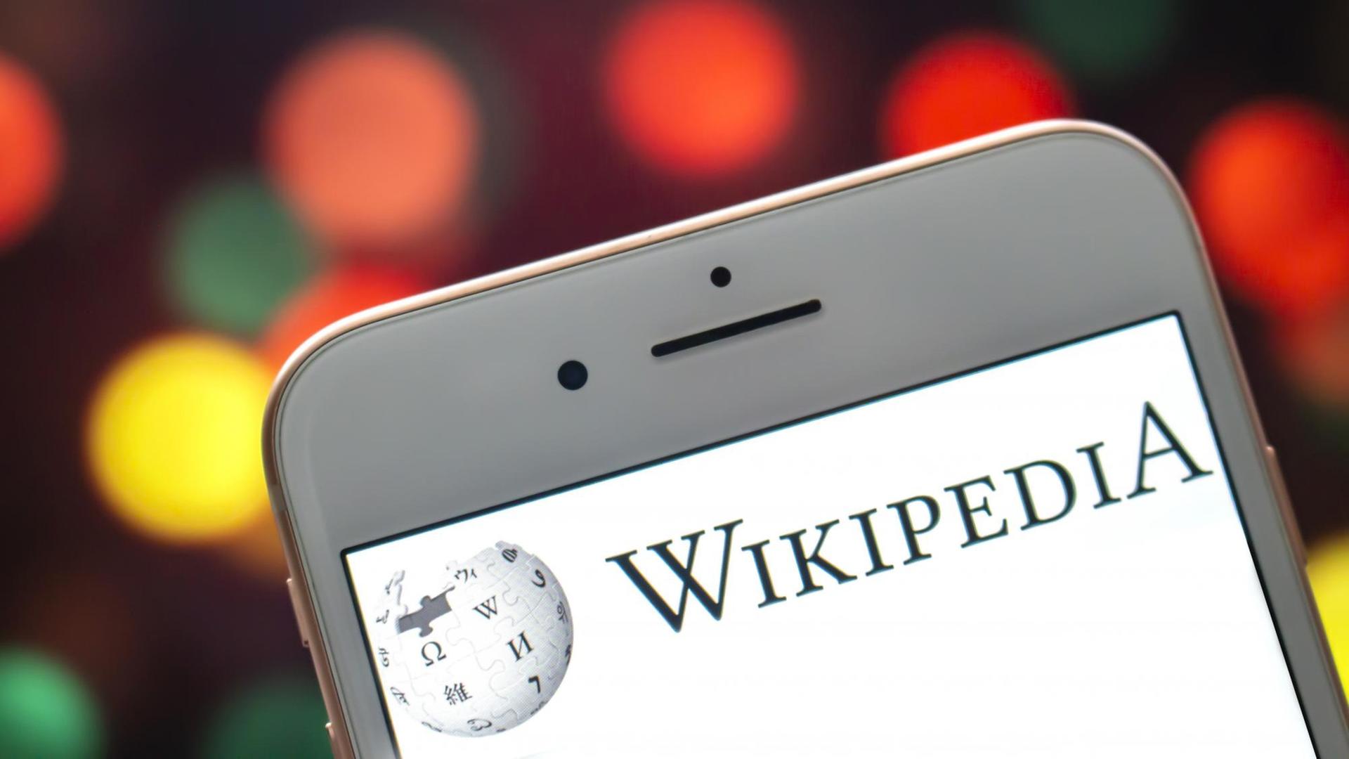 Das Wikipedia-Logo auf einem iPhone-Display.