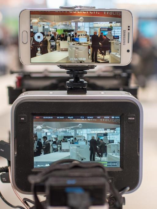 Kameramann filmt dual mit Kamera und einem Smartphone.