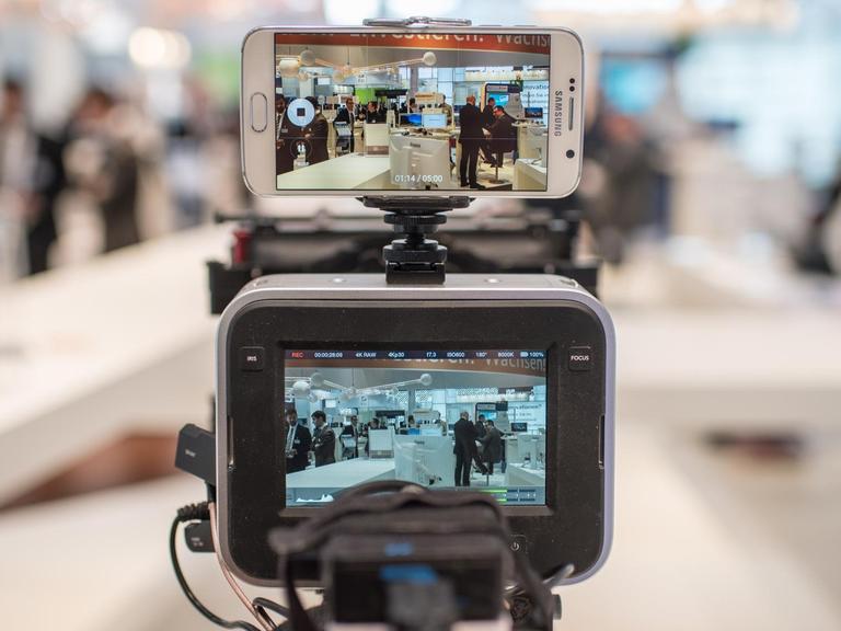 Kameramann filmt dual mit Kamera und einem Smartphone.