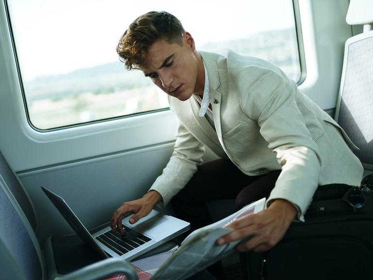 Ein junger Mann arbeitet im Zug