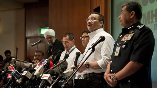 Auf einer Pressekonferenz des malaysischen Behörden stehen mehrere Männer hinter Mikrofonen