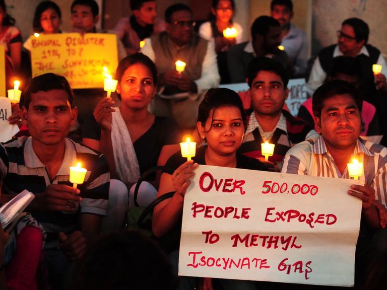 Mitglieder einer Nichtregierungsorganisation halten Plakate und Kerzen während des 30.Jahrestages der Bhopal-Katastrophe.