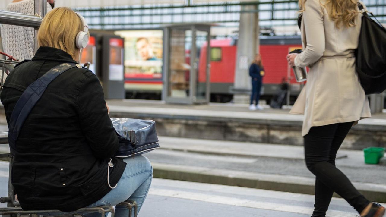 Eine Reisende sitzt am Stuttgarter Bahnhof.