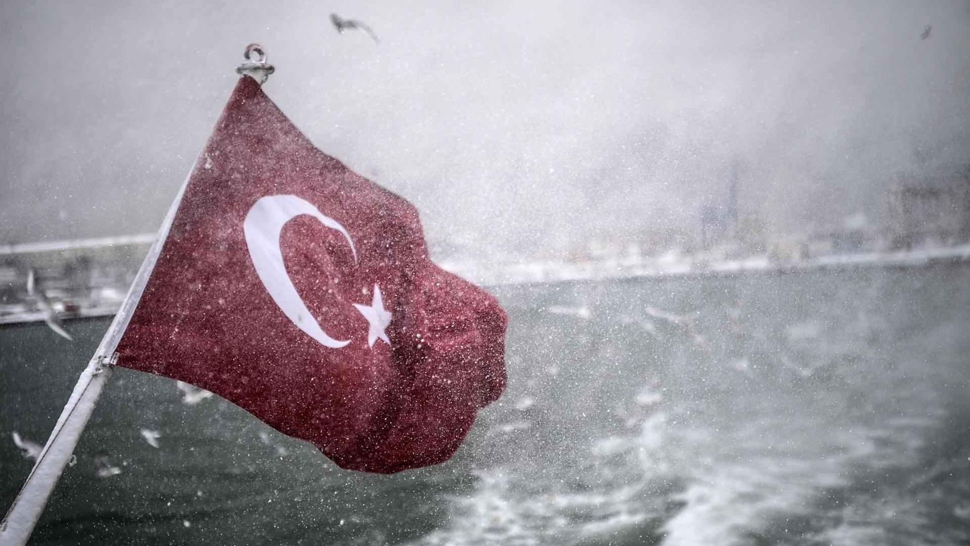 Türkische Fahne an einem Boot weht bei der Fahrt über den Bosporus bei trübem Wetter