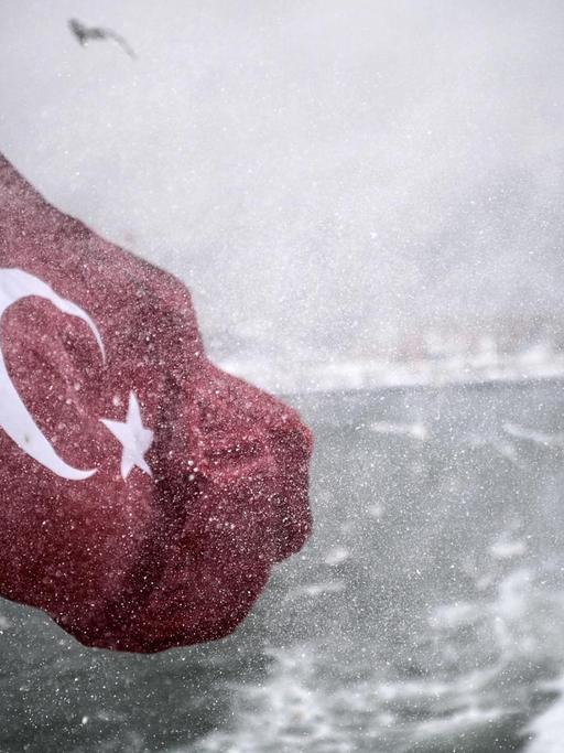 Türkische Fahne an einem Boot weht bei der Fahrt über den Bosporus bei trübem Wetter