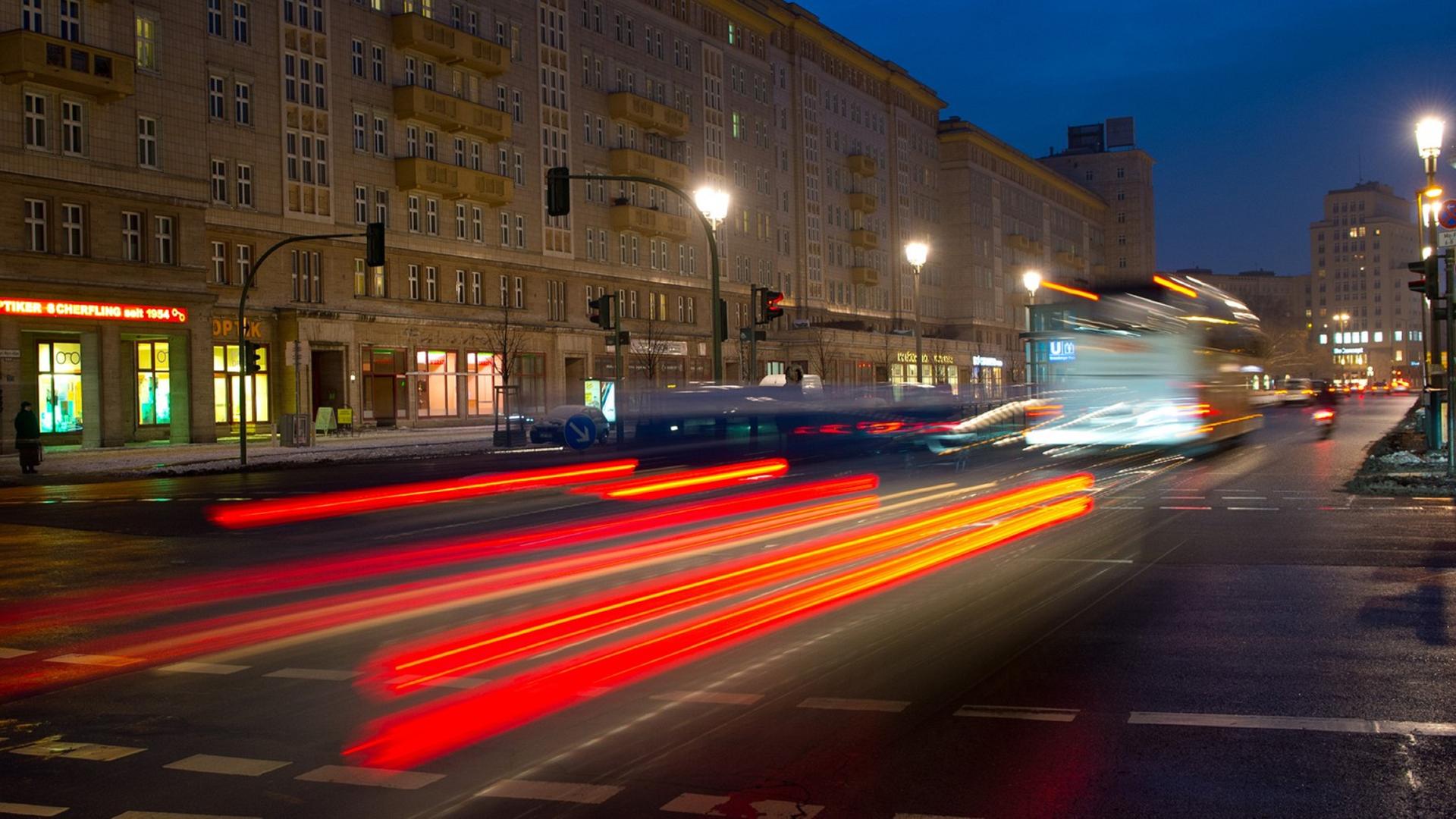 Die Rücklichter eines fahrenden Autos auf der Karl-Marx-Allee in Berlin.