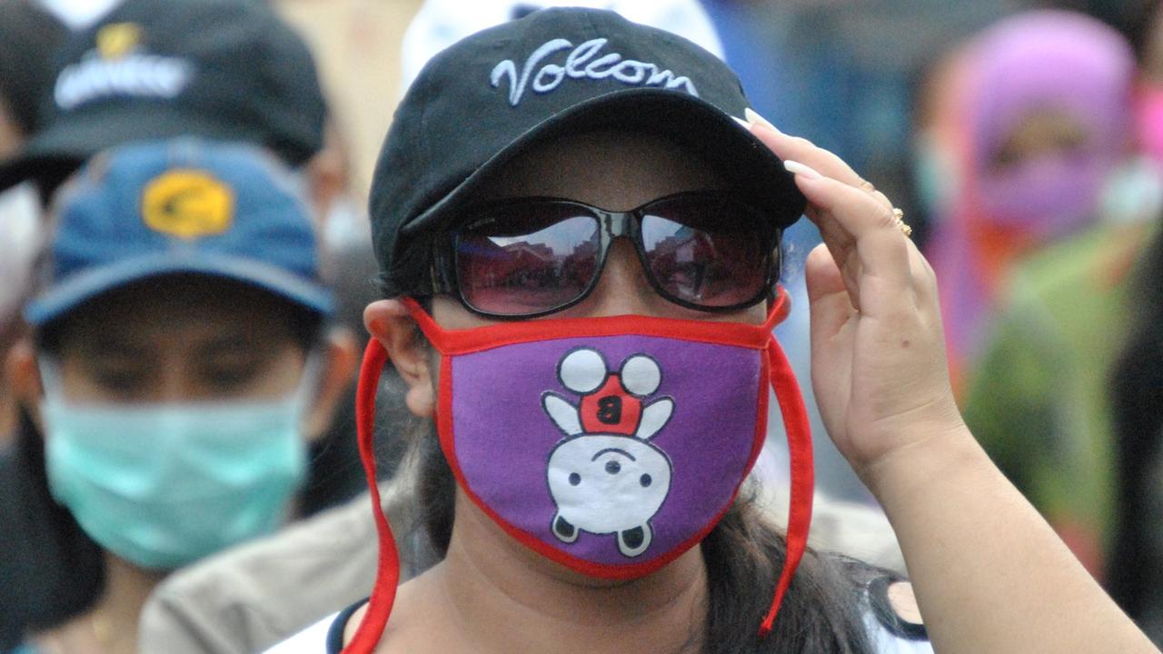 Vermummte Demonstrantin, die gegen die Schließung des Rotlicht-Viertels im indonesischen Surabaya protestiert.