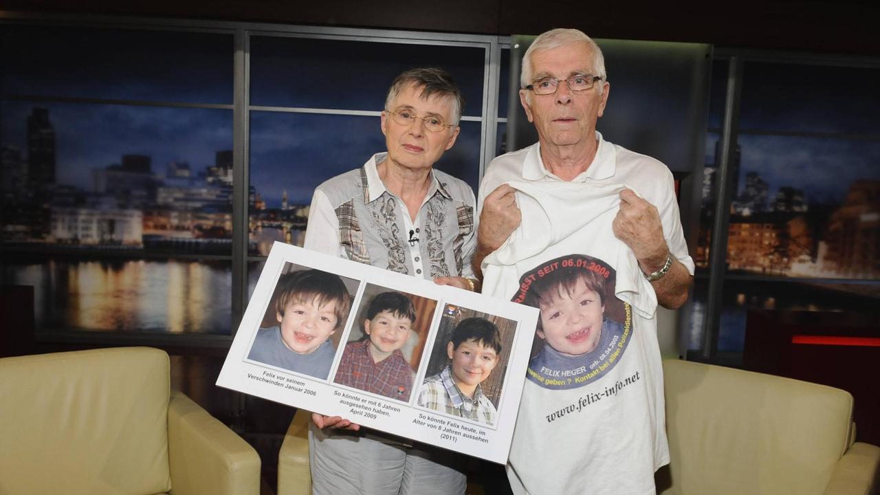 Johann und Maria Schmitz halten Bilder von ihrem vermissten Enkel in die Kamera.