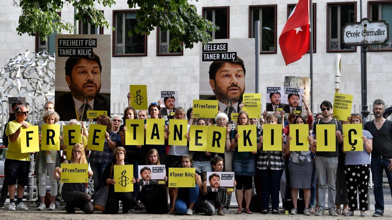 Mitglieder von Amnesty International fordern auf Transparenten die sofortige Freilassung von Taner Kilic, dem Vorsitzenden von Amnesty in der Türkei 
