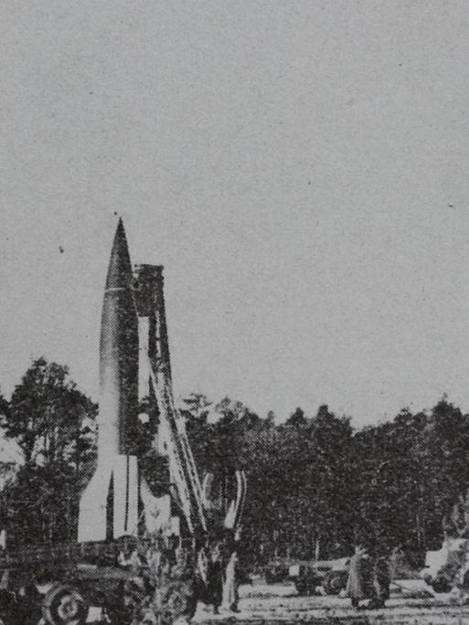 Schwarz-Weiß Fotografie, die drei Raketen auf einem Feld zeigt.
