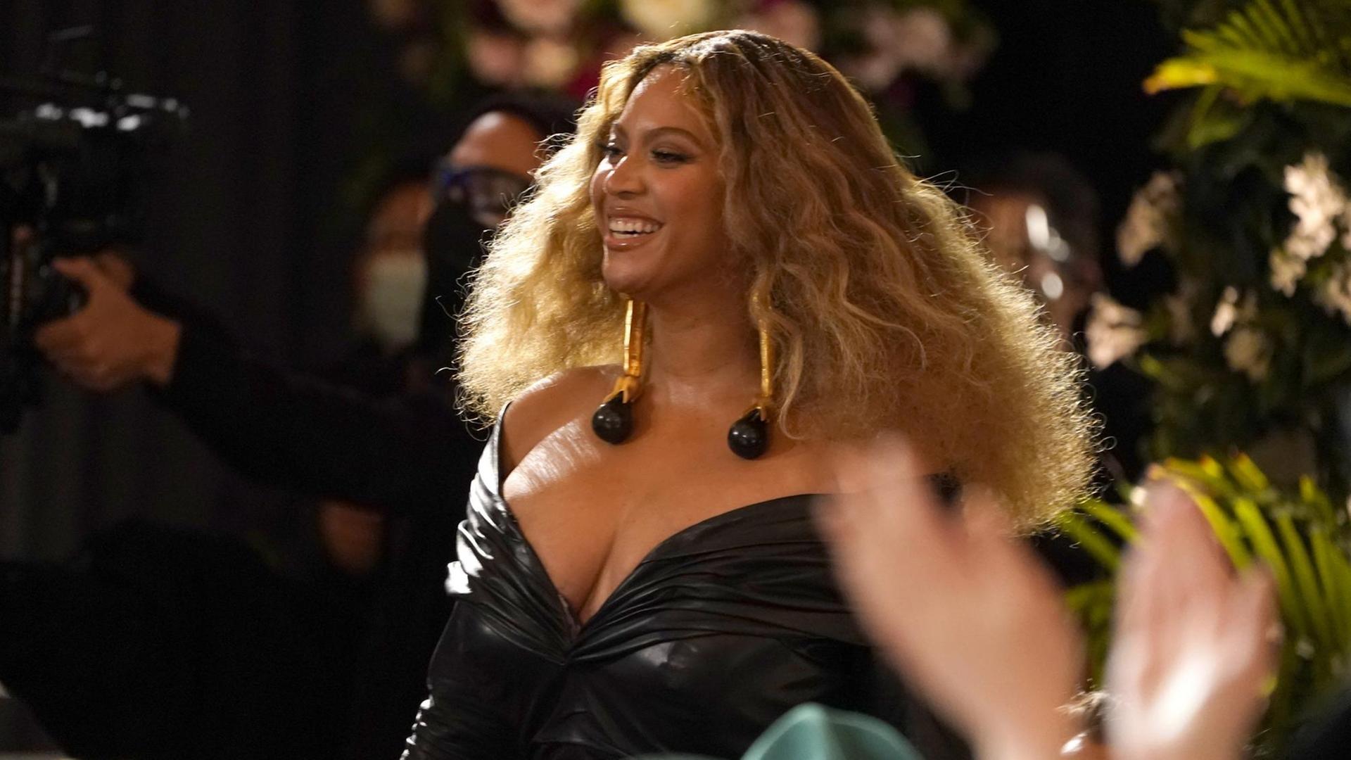 Das Archivbild zeigt die US-Sängerin Beyoncé lachend mit offenem blondem Haar und schwarzem Kleid bei Grammy-Verleihung 2021 Das Archivbild zeigt die US-Sängerin Beyoncé lachend mit offenem blondem Haar und schwarzem Kleid bei Grammy-Verleihung 2021