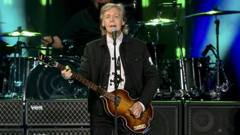 Der Ex-Beatles-Sänger, Sir Paul McCartney, steht während eines Konzerts gitarrespielend und singend auf der Bühne