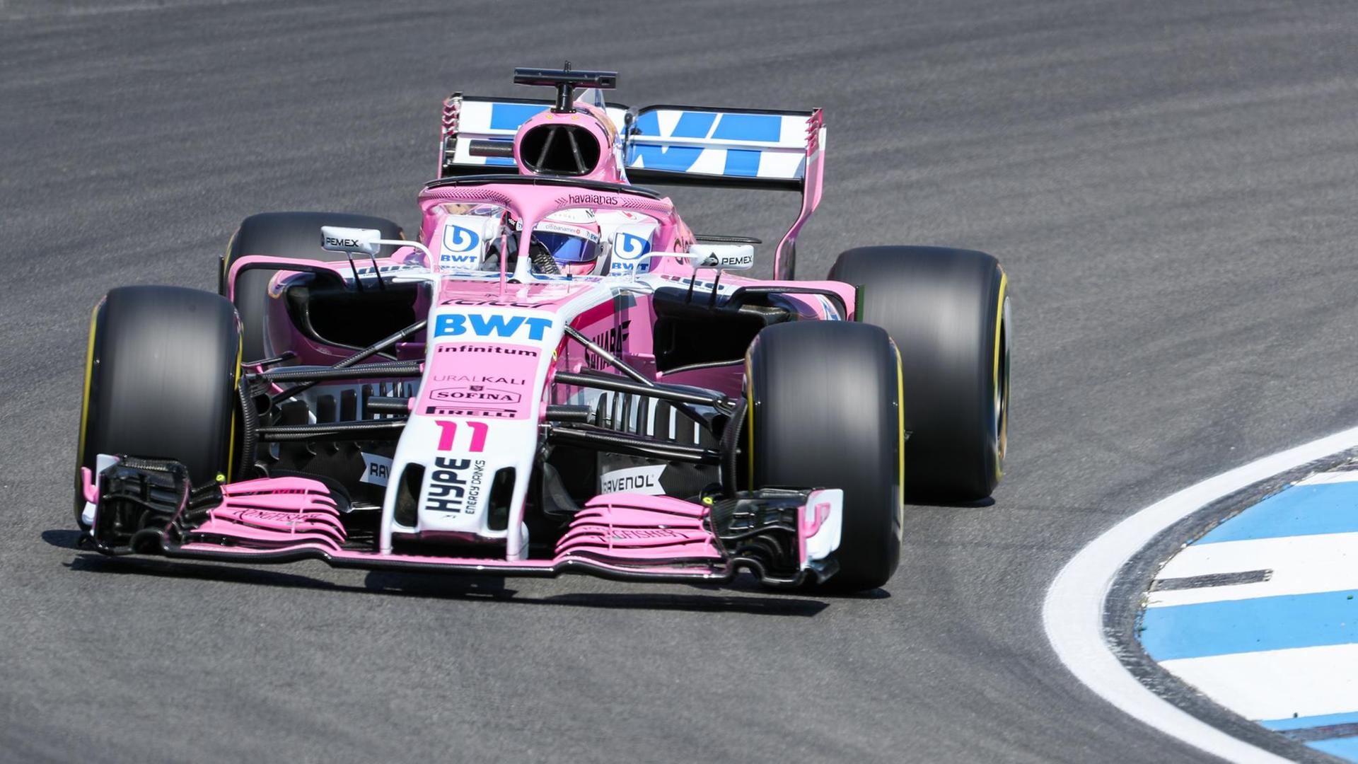 Ein Formel-1-Auto in rosa fährt um eine Kurve. Ein Formel-1-Auto in rosa fährt um eine Kurve.